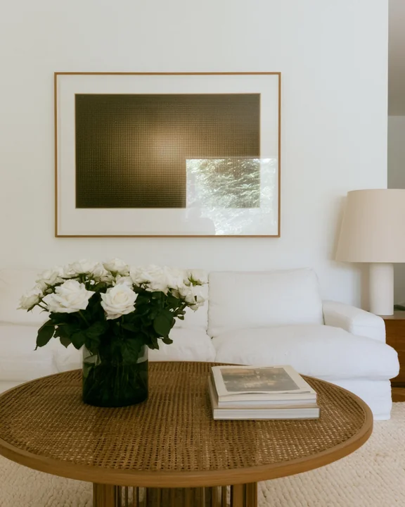 Wide living room with a textured relief artwork on the wall and roses on the coffee table