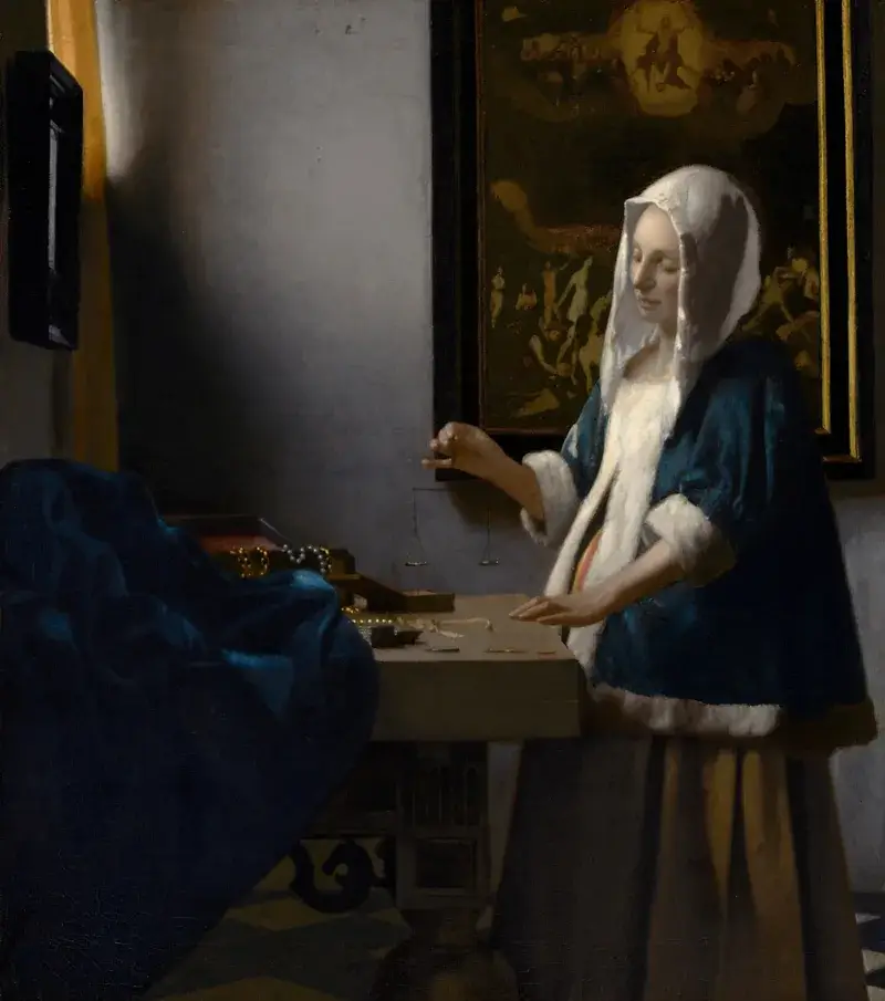 Johannes Vermeer, Woman Holding a Balance: a woman in a blue jacket stands at a table by a window, and a large painting of the Last Judgement hangs on the wall behind her
